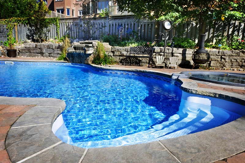 Pool remodeling is an excellent way to get the pool of your dreams like this in-ground pool with pristine water and curved edges.