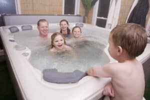 a father and his children enjoying a safe soak in a hot tub