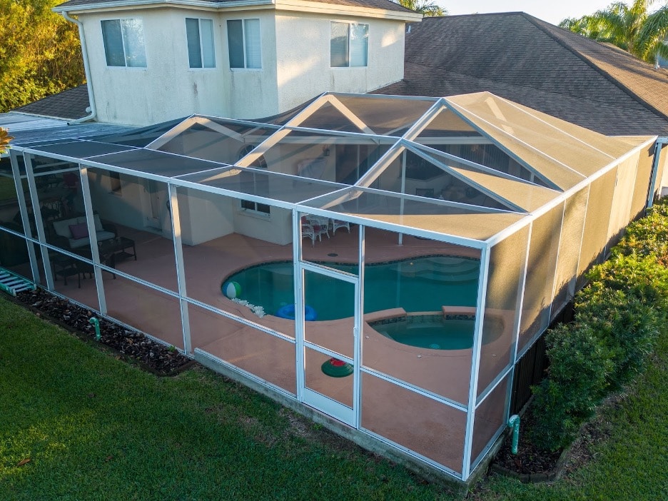 An outside view of a pool enclosure over a pool. 