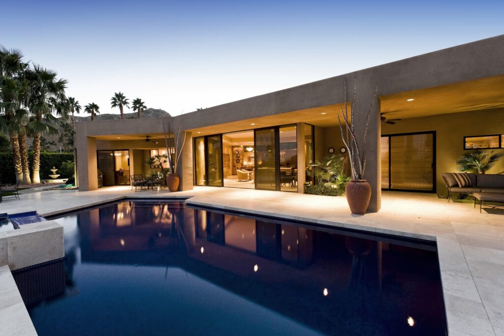 Beautiful concrete pool with a modern home.