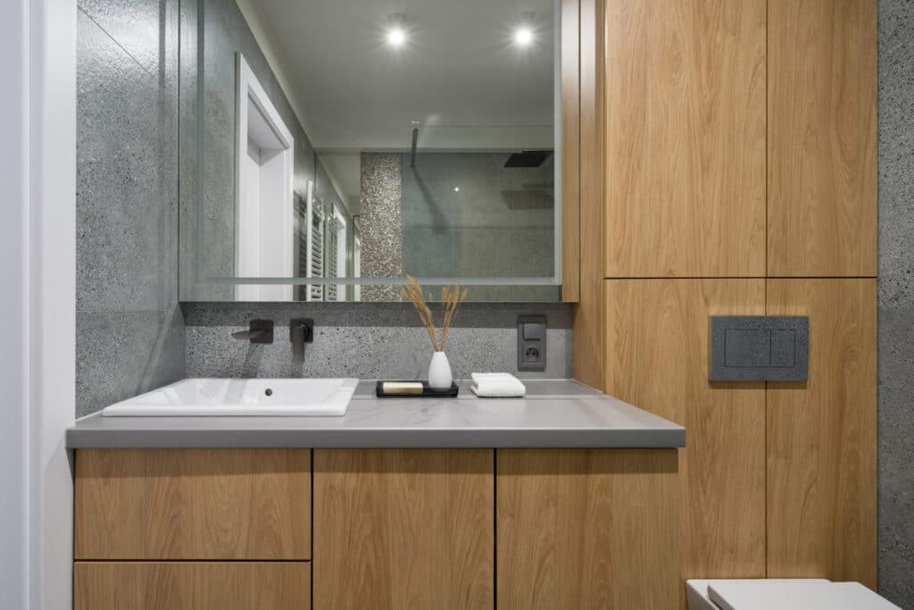 a bathroom that uses terrazzo tile and wooden accents 