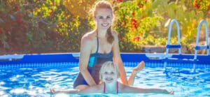 A mom and her daughter enjoy swimming in their above ground pool that they got with above ground pool financing