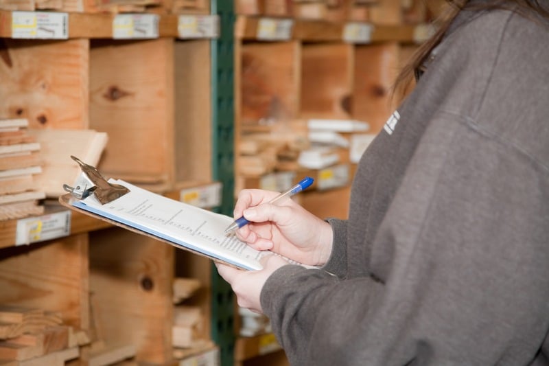 An inventory control solutions manager updates inventory with a clipboard.