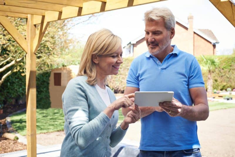 Middle aged couple reviewing marketing details for landscaping and design business