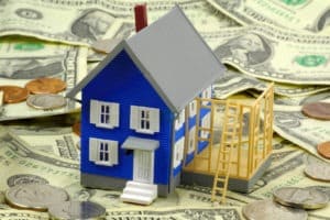 Small model house among home improvement financing money
