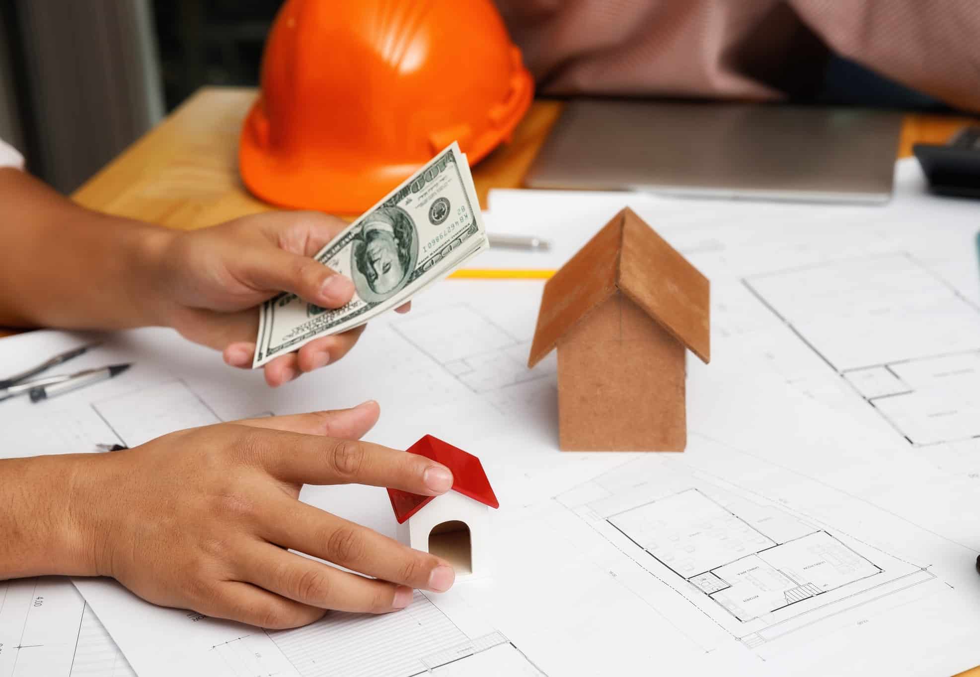Contractor thinking about financing over blueprints