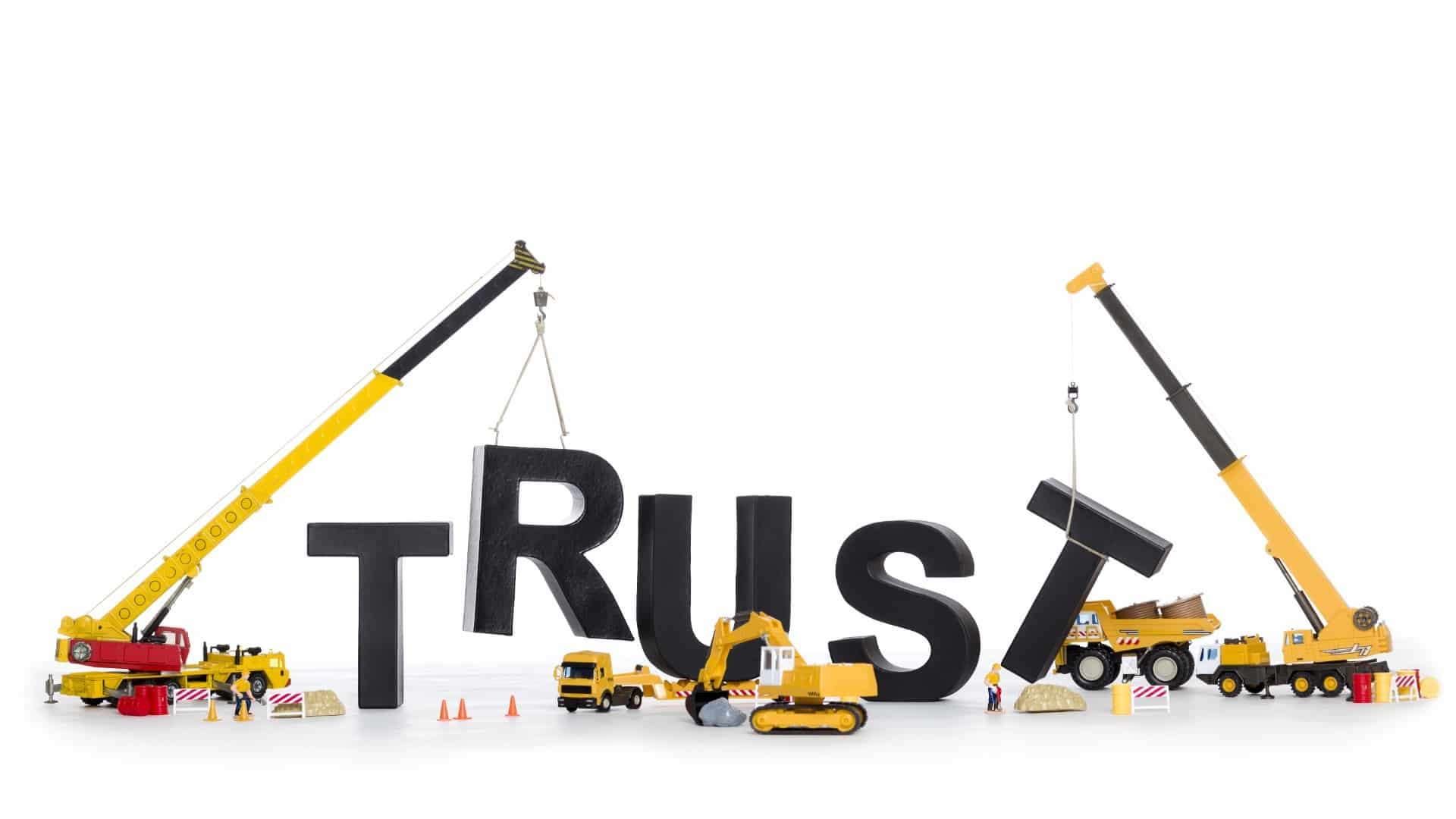 Toy construction equipment building the word "trust"