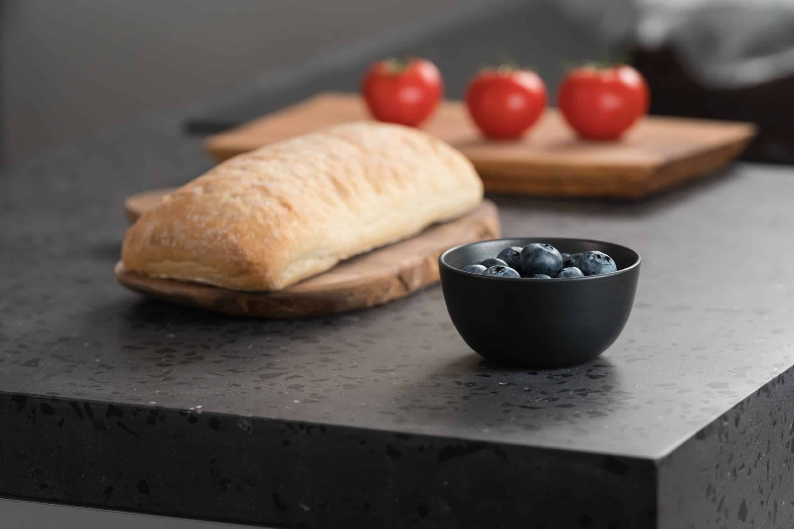 Bread and fruit sitting on concrete kitchen countertop