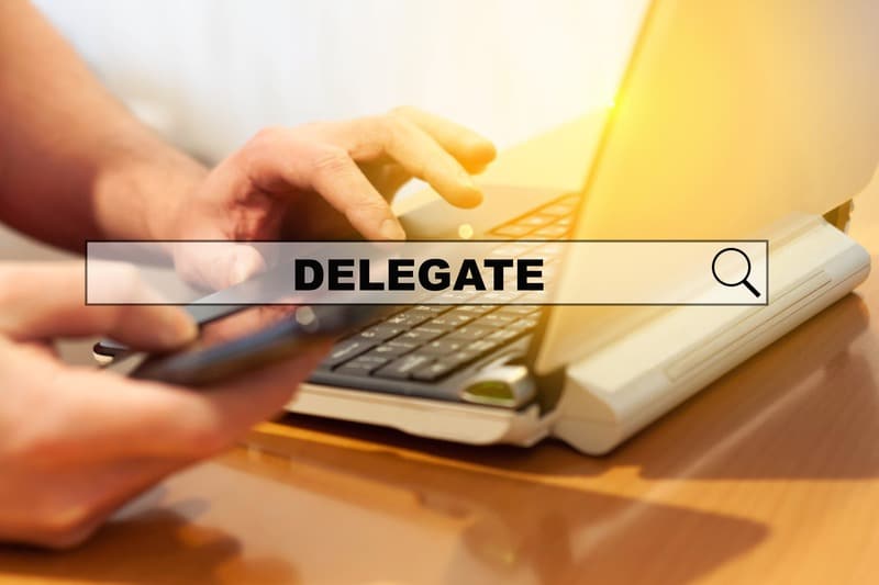 A business owner searches the word “delegate” on his laptop. He is trying one of our 3 practical anti-stress tips for business owners.