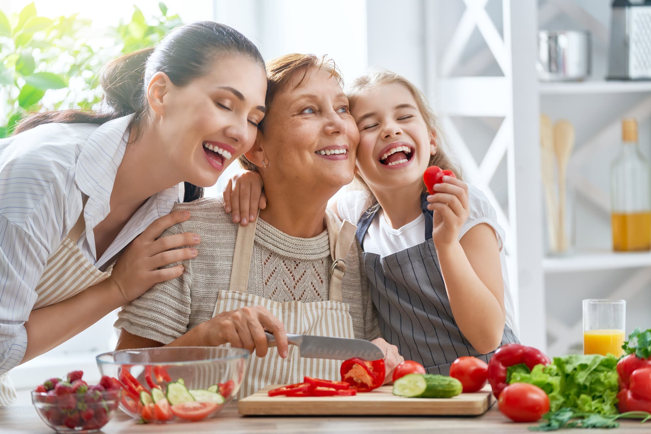 Mother, grandmother, and daughter enjoying fresh produce in remodeled kitchen