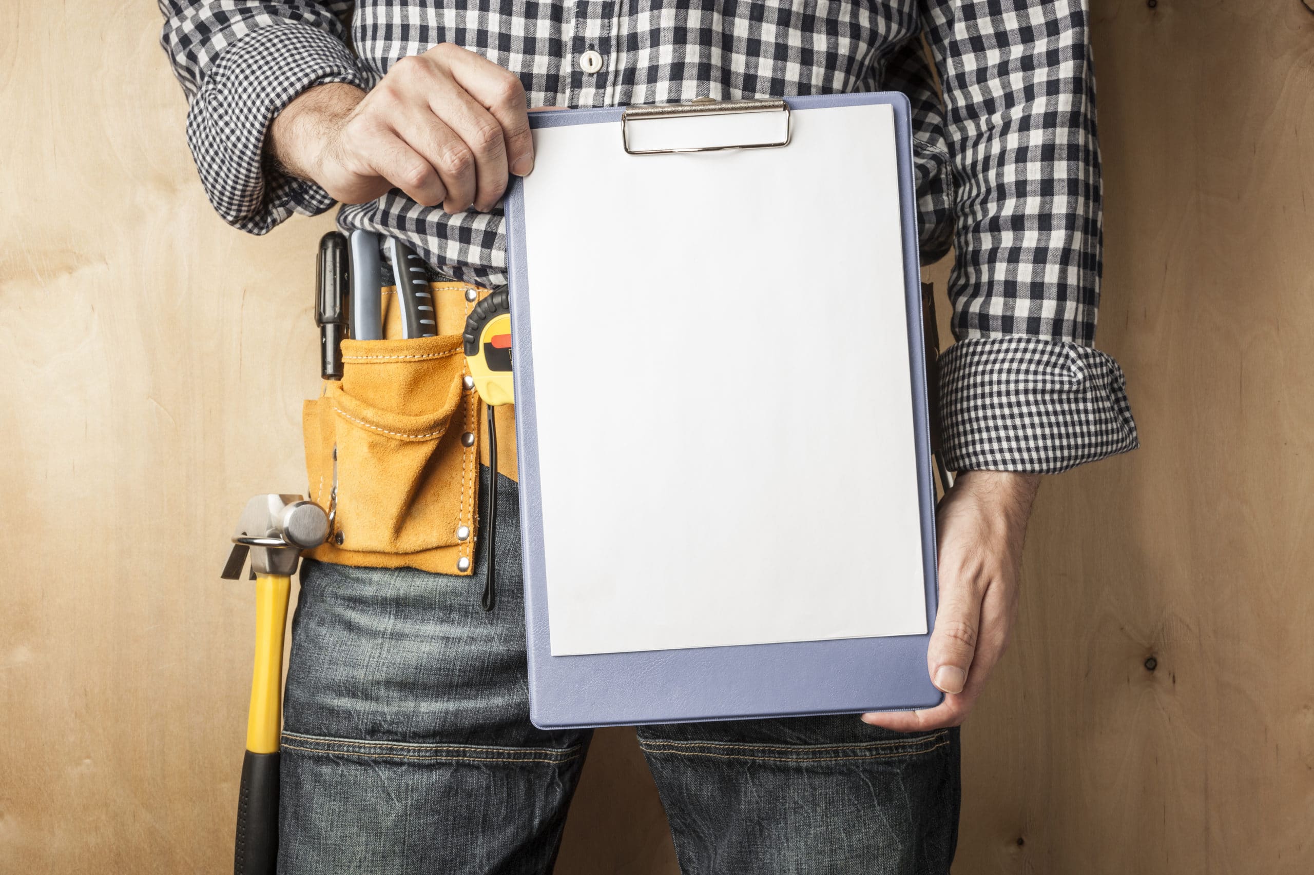 a contractor stands with a clipboard list of construction business clients