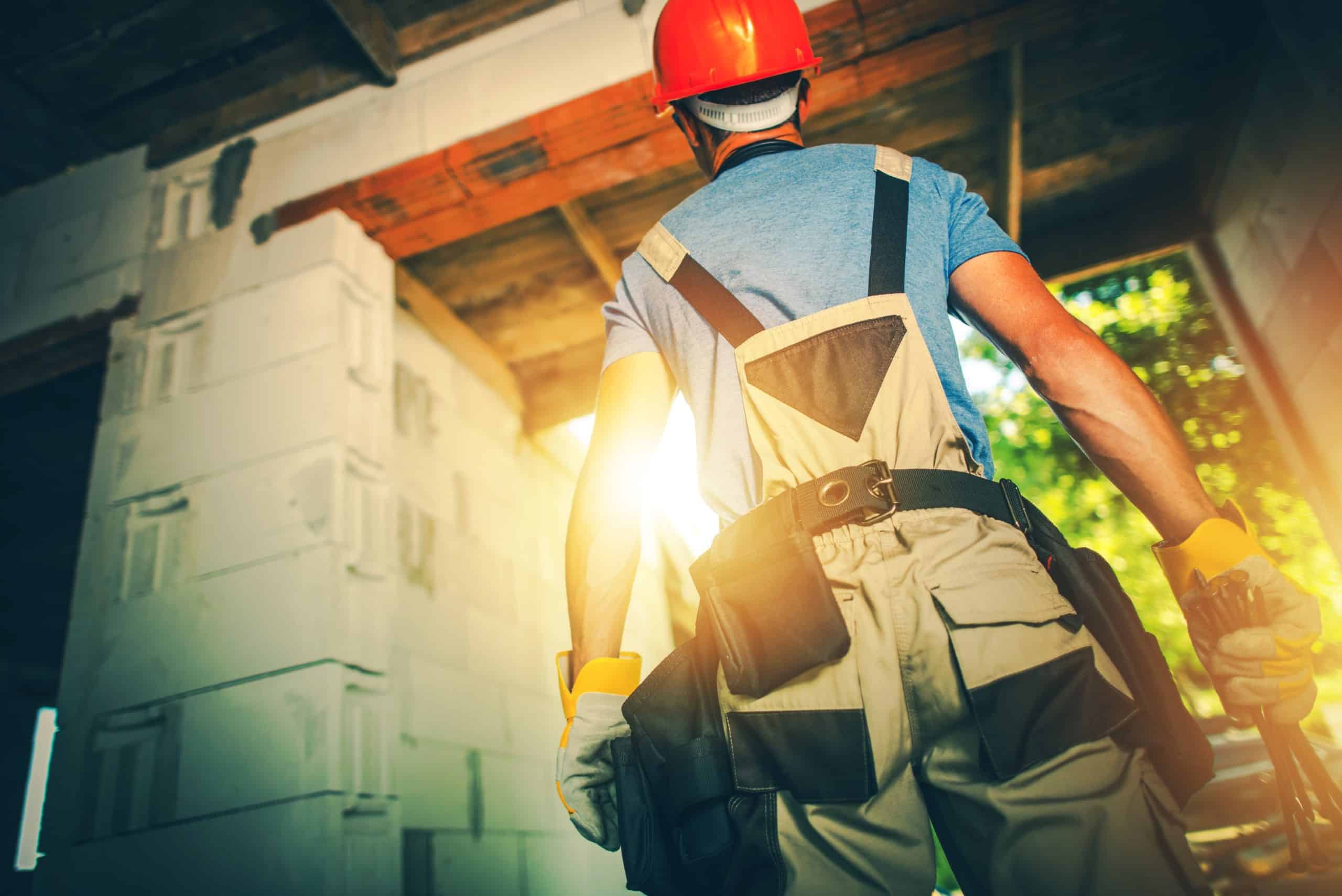 a contractor wearing a red hardhat and a tool belt walks into a sunset to make the most of his off-season