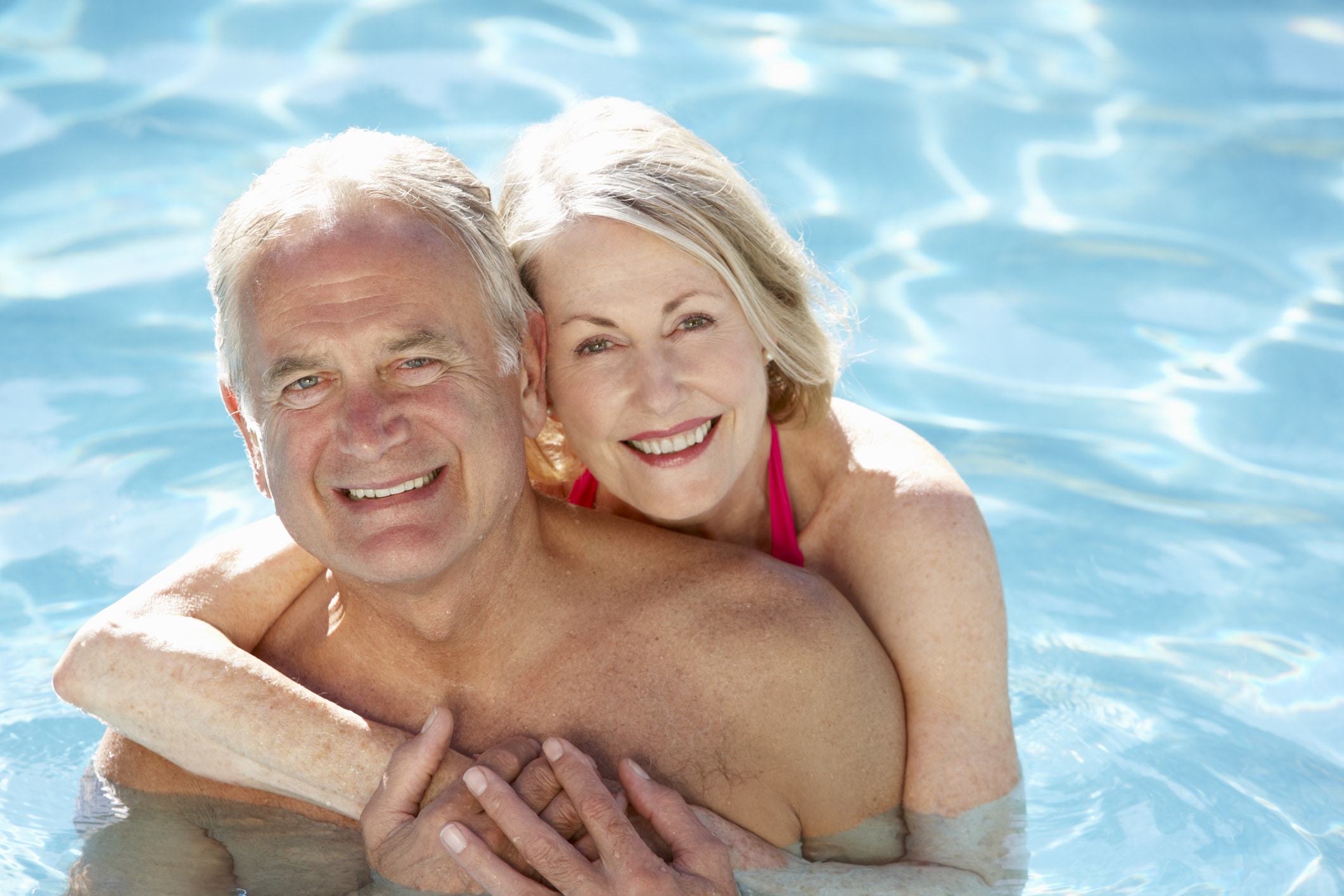 Elderly Couple hugging in pool