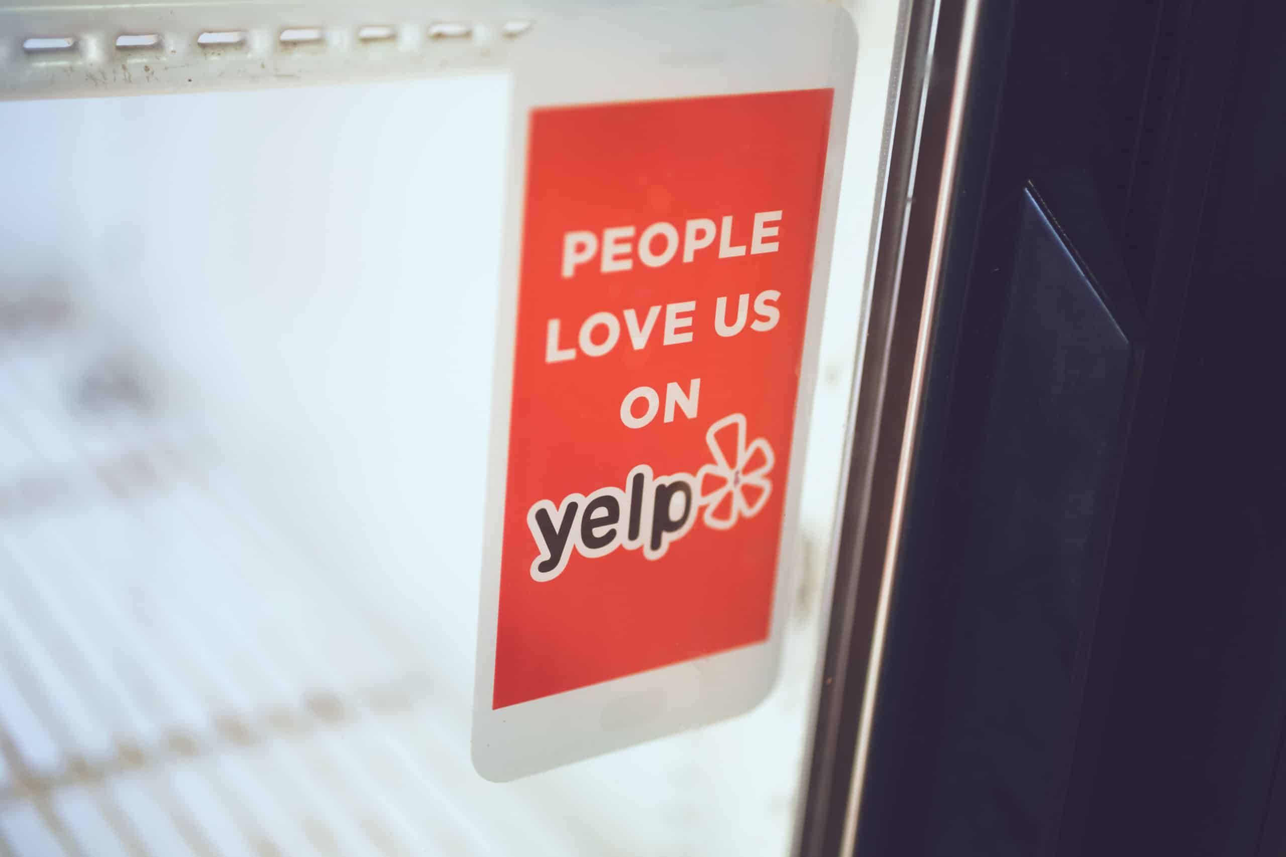 A Yelp! sticker on the door of a general contractor business helps people review businesses.