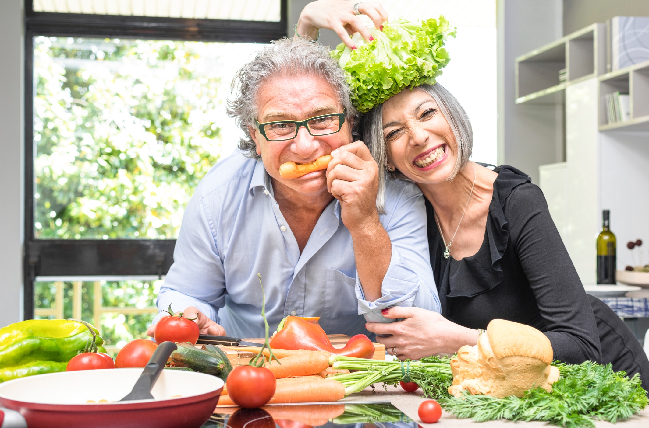 Elderly couple enjoying fresh produce in kitchen