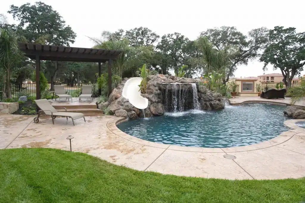 Luxury backyard and luxury swimming pool with waterfall water features.