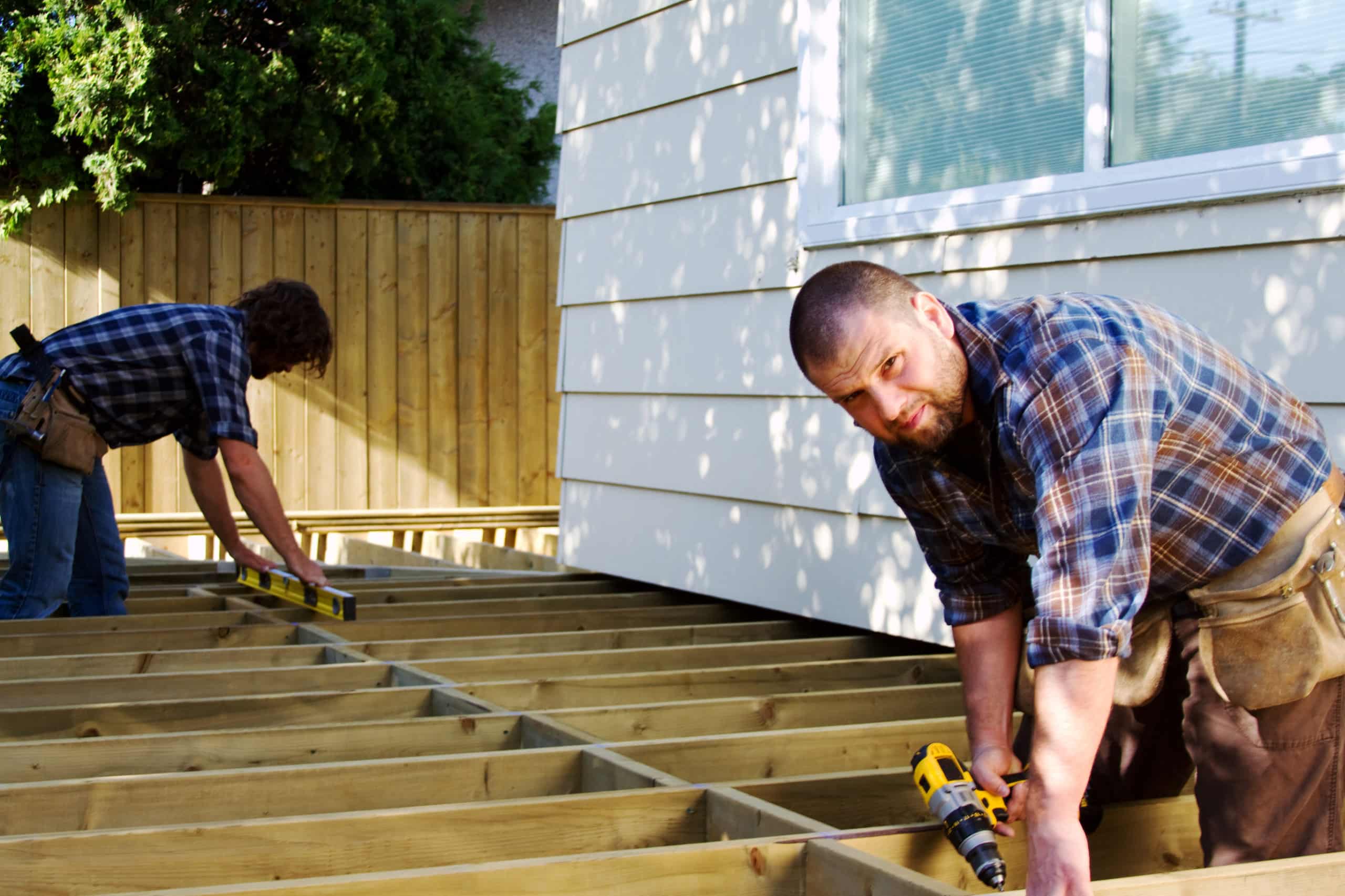 A fencing and decking contractor team build a deck.