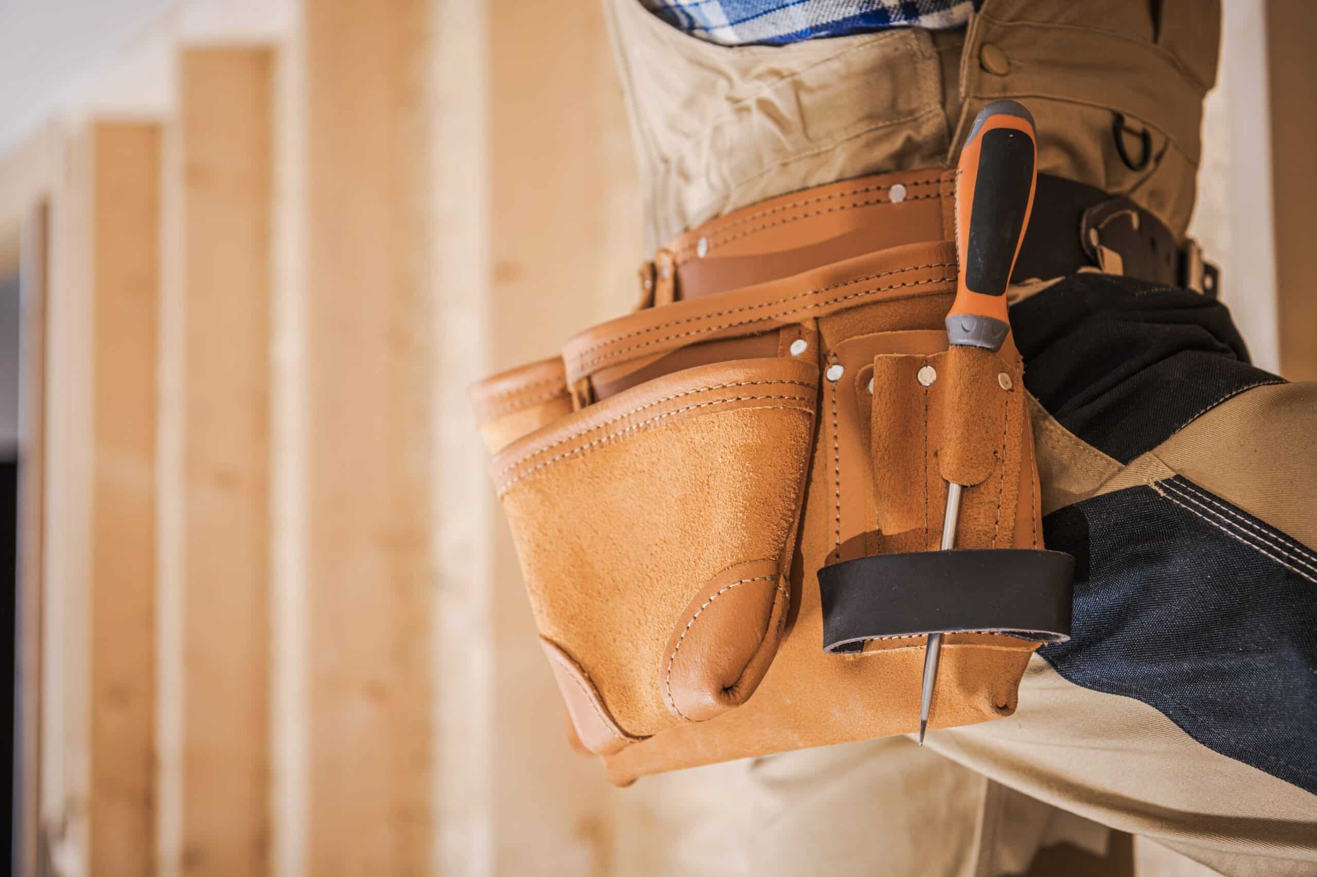 A home improvement contractor's tool belt is visible as he works to renovate a home and dominate the competition your market.
