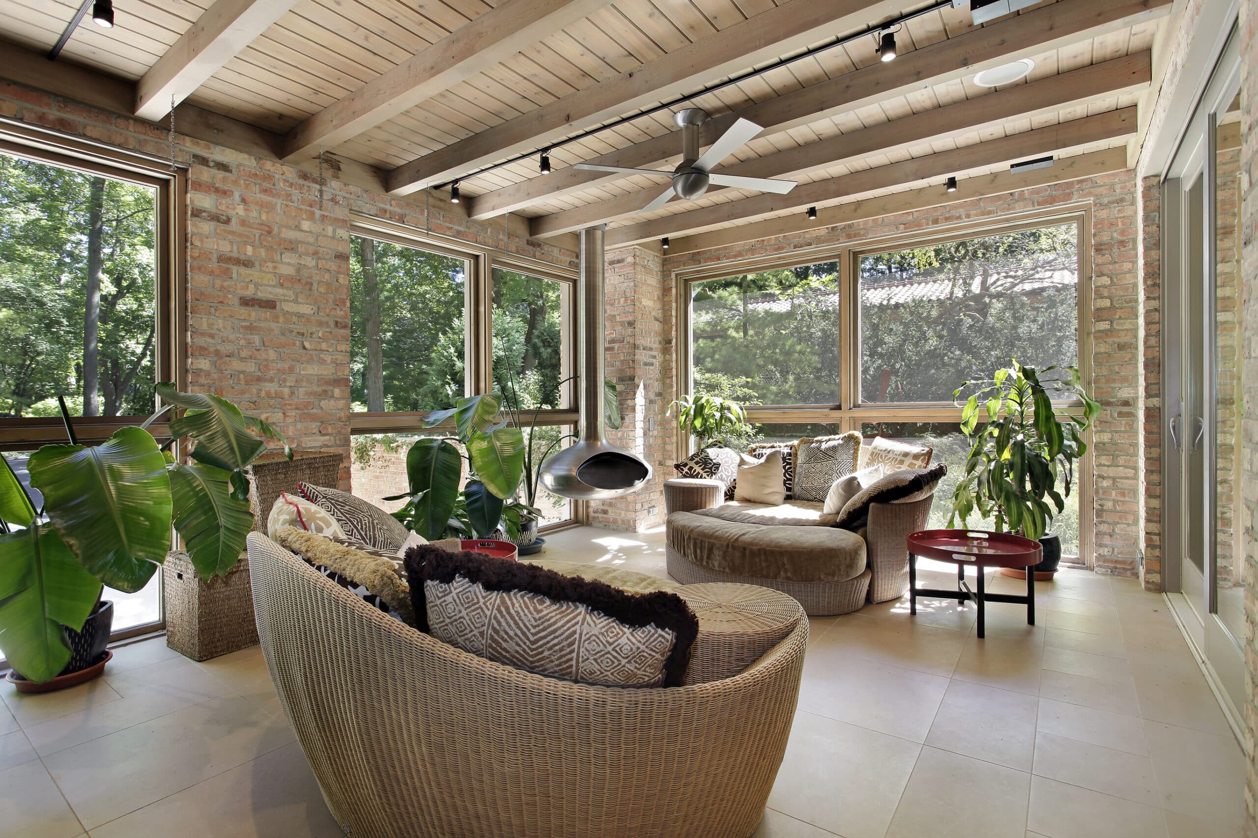 A beautiful brick sunroom with patio furniture and gentle natural lighting gives the perfect example for the sunroom builder's guide to dominating the competition.