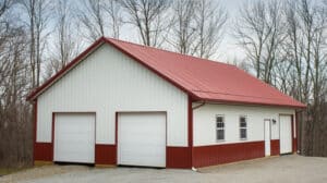 Building a pole barn using pole barn financing from HFS Financial can get you a beautiful pole barn like this pole barn with a red roof and double garages.