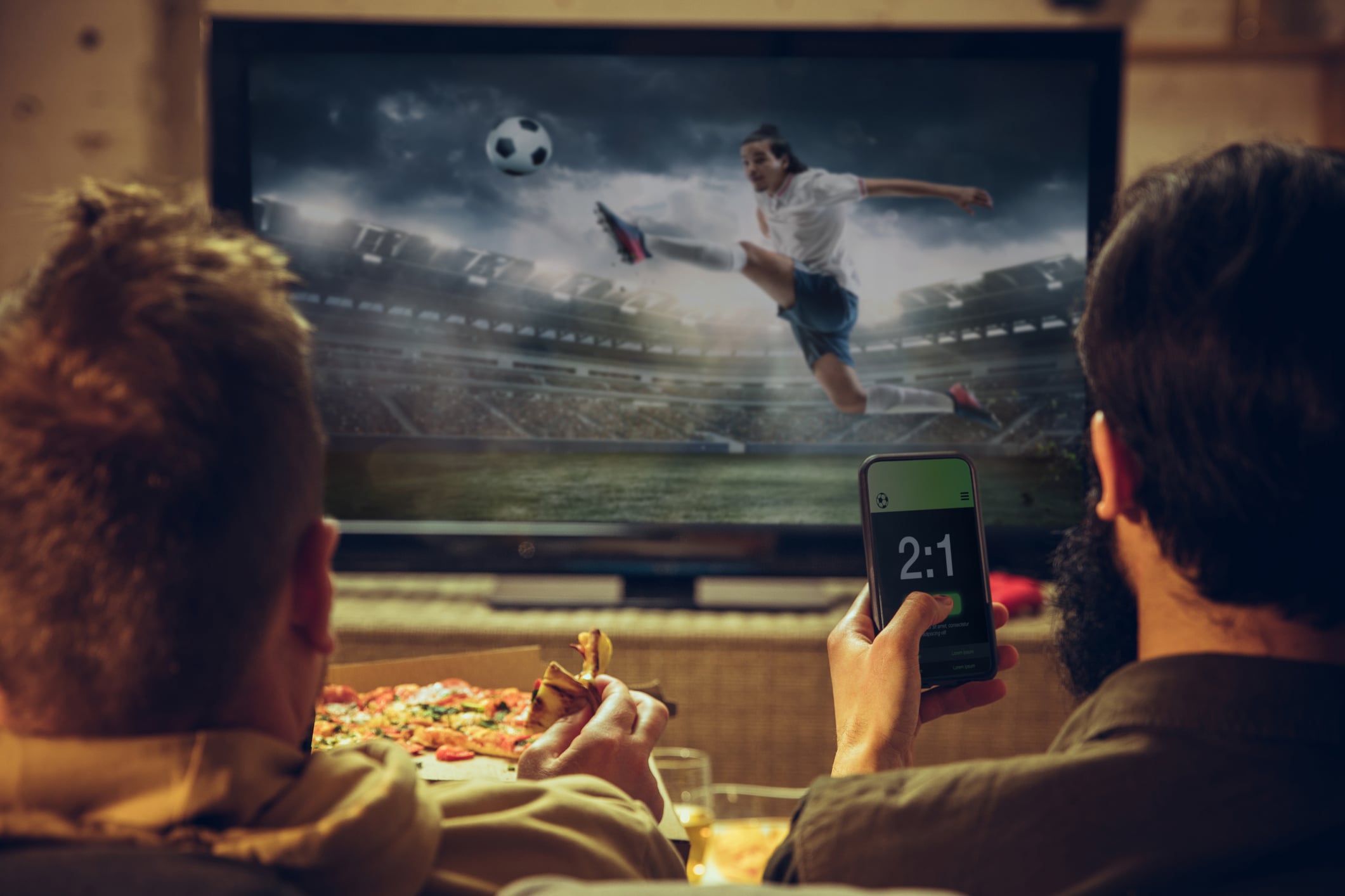 Two men watch a soccer game in their man cave with man cave loans