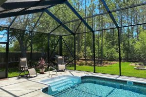 A large pool enclosure over an inground pool.